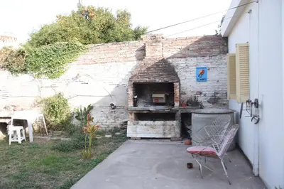 a brick wall with a pizza oven in a yard at La casa de Mirta Habitaciones en Córdoba in Cordoba