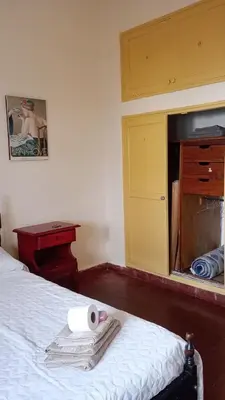 a bedroom with a bed with a roll of toilet paper on it at La casa de Mirta Habitaciones en Córdoba in Cordoba