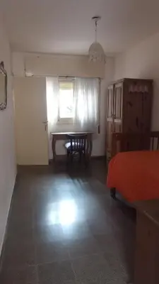 a bedroom with a table and a bed and a window at La casa de Mirta Habitaciones en Córdoba in Cordoba