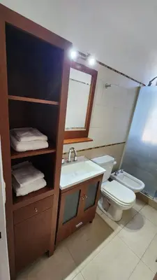 a bathroom with a sink and a toilet and a mirror at Depto San Martín VCP in Villa Carlos Paz