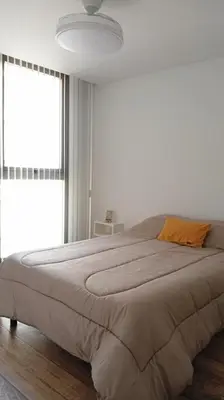 a bedroom with a large bed with a large window at Sam Gabrielll in Villa Carlos Paz