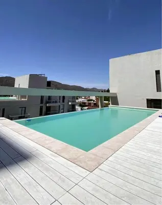 a large blue swimming pool on the side of a building at Sam Gabrielll in Villa Carlos Paz