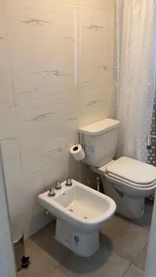 a white bathroom with a toilet and a sink at Sam Gabrielll in Villa Carlos Paz