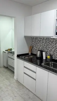 a white kitchen with white cabinets and a sink at Sam Gabrielll in Villa Carlos Paz