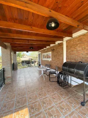 a large patio with a wooden ceiling and a large cannon at Complejo Caeiro in Bialet Massé