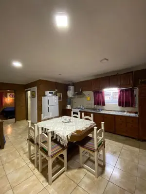 a kitchen with a table and chairs in a kitchen at Complejo Caeiro in Bialet Massé