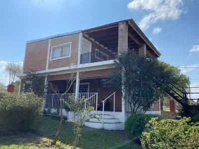 a brick house with a balcony on top of it at Complejo Caeiro in Bialet Massé