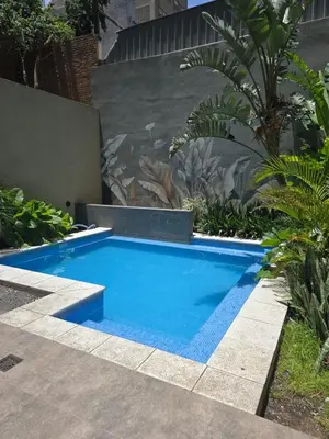 a small blue swimming pool in a garden at Dpto NVA CBA calle OBISPO TREJO con PILETA y QUINCHO in Cordoba