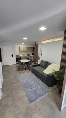 a living room with a couch and a table at Dpto NVA CBA calle OBISPO TREJO con PILETA y QUINCHO in Cordoba