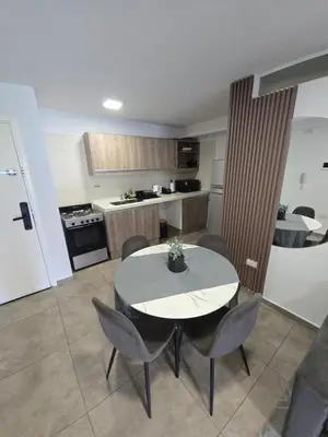 a kitchen with a table and chairs in a room at Dpto NVA CBA calle OBISPO TREJO con PILETA y QUINCHO in Cordoba
