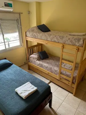 a bedroom with two bunk beds and a bench at Bv San Juan - Nueva Cordoba 2 in Cordoba