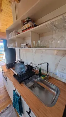 a kitchen with a sink and a counter with glasses at Entre Sierras y Sueños in Villa Yacanto
