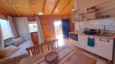 a kitchen and living room of a log cabin at Entre Sierras y Sueños in Villa Yacanto