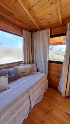 a bed in a room with a large window at Entre Sierras y Sueños in Villa Yacanto