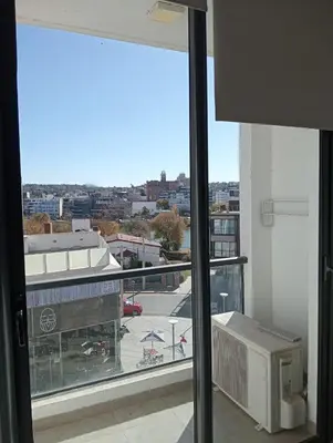 a view of a city from a window in a building at Departamento Carlos Paz Paseo Quattro 36 Cochera Piscina Céntrico in Villa Carlos Paz