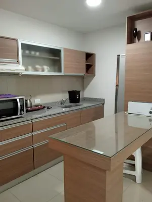 a kitchen with wooden cabinets and a counter top at Departamento Carlos Paz Paseo Quattro 36 Cochera Piscina Céntrico in Villa Carlos Paz