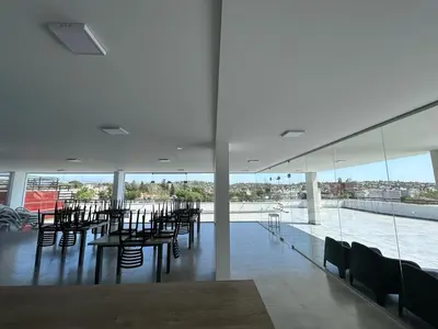 a room with tables and chairs and a view of the water at Departamento Carlos Paz Paseo Quattro 36 Cochera Piscina Céntrico in Villa Carlos Paz