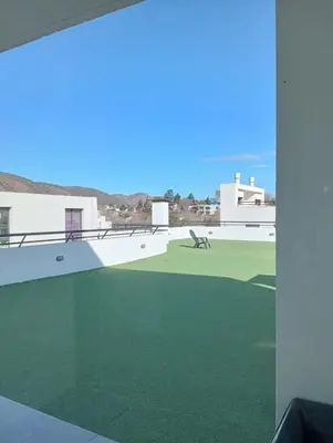 a view from the balcony of a house with green grass at Departamento Carlos Paz Paseo Quattro 36 Cochera Piscina Céntrico in Villa Carlos Paz