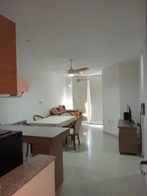 a living room with a bed and a table at Departamento Carlos Paz Paseo Quattro 36 Cochera Piscina Céntrico in Villa Carlos Paz