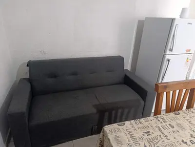 a gray chair in a kitchen next to a refrigerator at Departamento tolosa in Cordoba