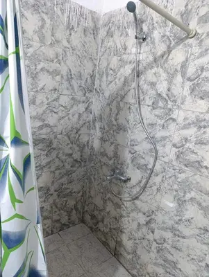 a shower in a bathroom with a stone wall at Departamento tolosa in Cordoba