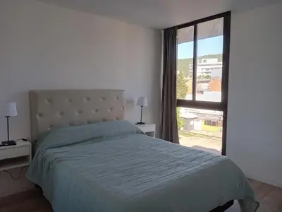 a bedroom with a bed and a large window at Sam Lake 3 in Villa Carlos Paz