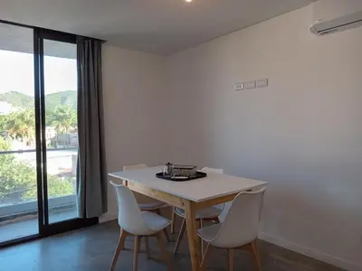 a dining room with a table and chairs and a large window at Sam Lake 3 in Villa Carlos Paz