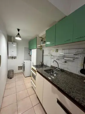 a kitchen with green cabinets and a sink at poeta lugones - nva cba in Cordoba