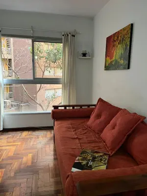a living room with a couch and a large window at poeta lugones - nva cba in Cordoba