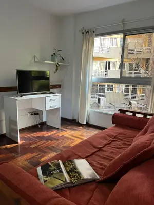 a living room with a couch and a large window at poeta lugones - nva cba in Cordoba