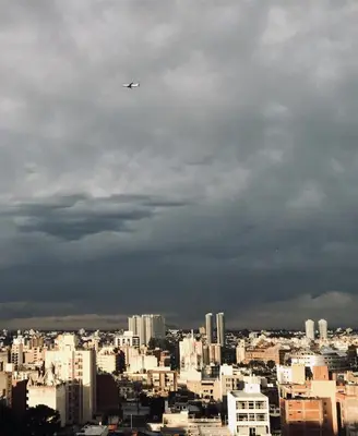a plane flying in the sky over a city at Amplio, luminoso y cerca de todo! in Cordoba