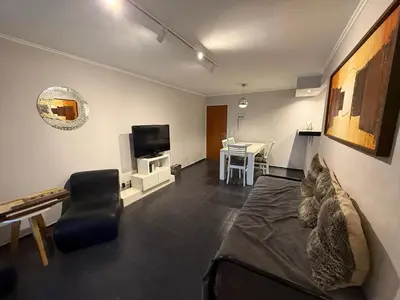 a living room with a couch and a tv at Amplio, luminoso y cerca de todo! in Cordoba