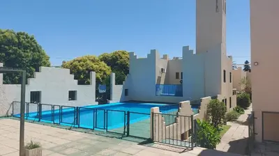 a swimming pool in front of a building at Castillo Del Lago - Carlos Paz - D18 in Villa Carlos Paz