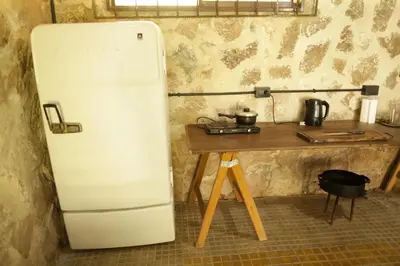 a white refrigerator next to a table in a kitchen at Apartamento por día Cuesta Blanca in Cuesta Blanca