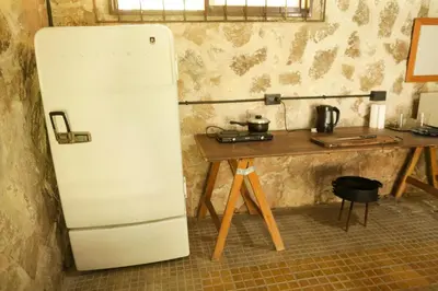 a white refrigerator next to a wooden table at Apartamento por día Cuesta Blanca in Cuesta Blanca