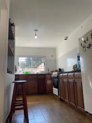 a kitchen with wooden cabinets and a stove top oven at Casa de Gregorio Hostel in Cordoba