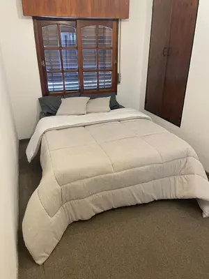 a large bed in a bedroom with a large window at Casa de Gregorio Hostel in Cordoba
