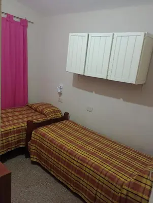 two beds in a hotel room with white cabinets at Casa ideal Pileta, Quincho y Patio Enorme in Bialet Massé
