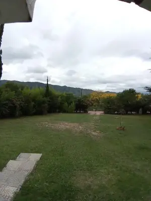 a grassy field with trees and mountains in the background at Casa ideal Pileta, Quincho y Patio Enorme in Bialet Massé