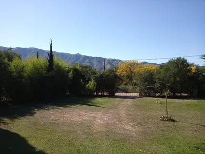 a large yard with trees and mountains in the background at Casa ideal Pileta, Quincho y Patio Enorme in Bialet Massé