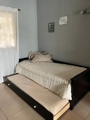 a bed in the corner of a room at Casa completa con pileta y asador, a metros del lago in Villa Carlos Paz