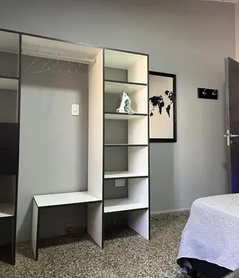 a bedroom with a bed and a closet with shelves at Casa completa con pileta y asador, a metros del lago in Villa Carlos Paz