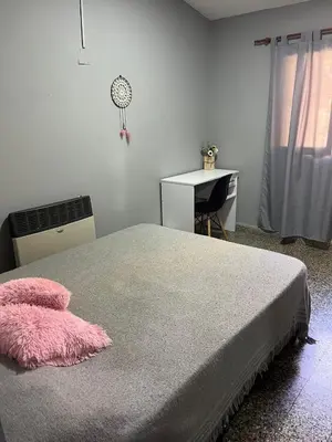 a bedroom with a bed and a desk and a desk at Casa completa con pileta y asador, a metros del lago in Villa Carlos Paz