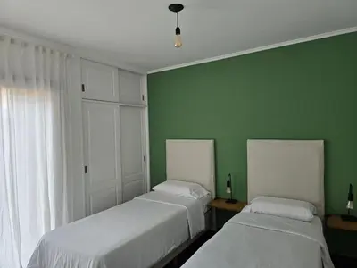 two beds in a room with green walls at ByB ALQUILERES 3 in Cordoba