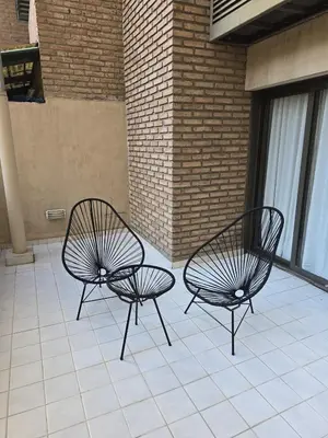 two black chairs sitting on a tile patio at ByB ALQUILERES 3 in Cordoba