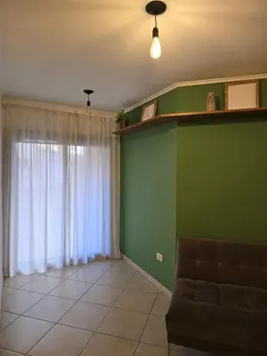 a living room with a couch and a green wall at ByB ALQUILERES 3 in Cordoba