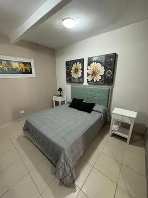 a bedroom with a bed and two pictures on the wall at Apart Suipacha in Río Cuarto