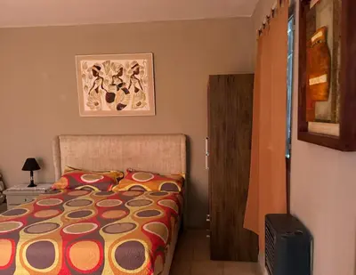 a bedroom with a bed with a colorful comforter at Apart Suipacha in Río Cuarto