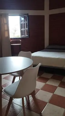 a room with a table and chairs and a bed at Departamento en Nono Descanso y aventura in Nono
