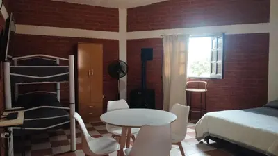 a bedroom with a bed and a table and chairs at Departamento en Nono Descanso y aventura in Nono